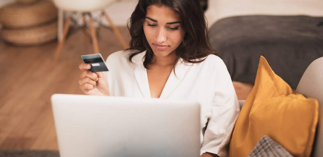 front-view-shot-woman-holding-credit-card-using-her-laptop