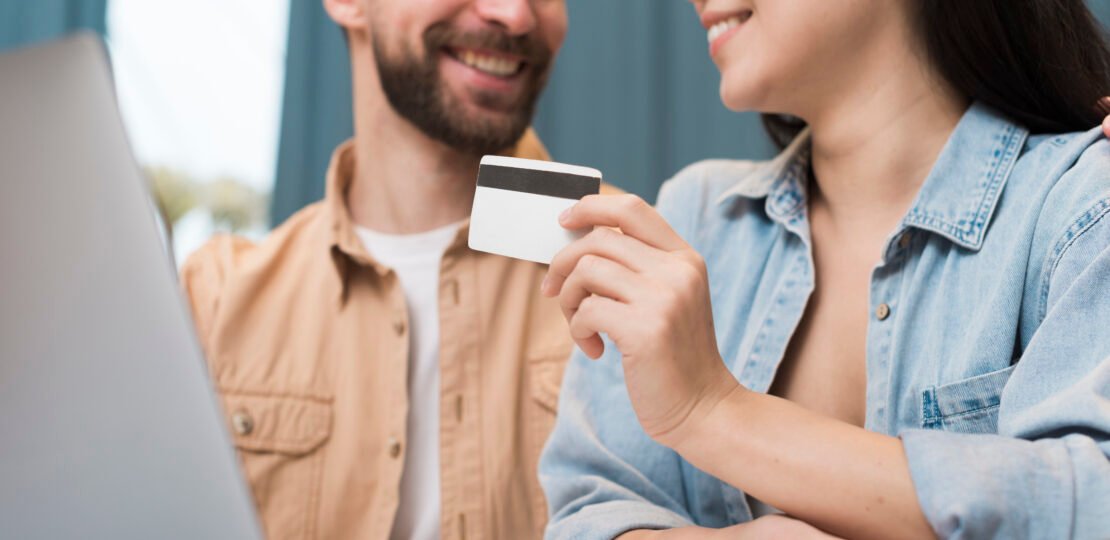 happy-couple-shopping-online-using-laptop-credit-card