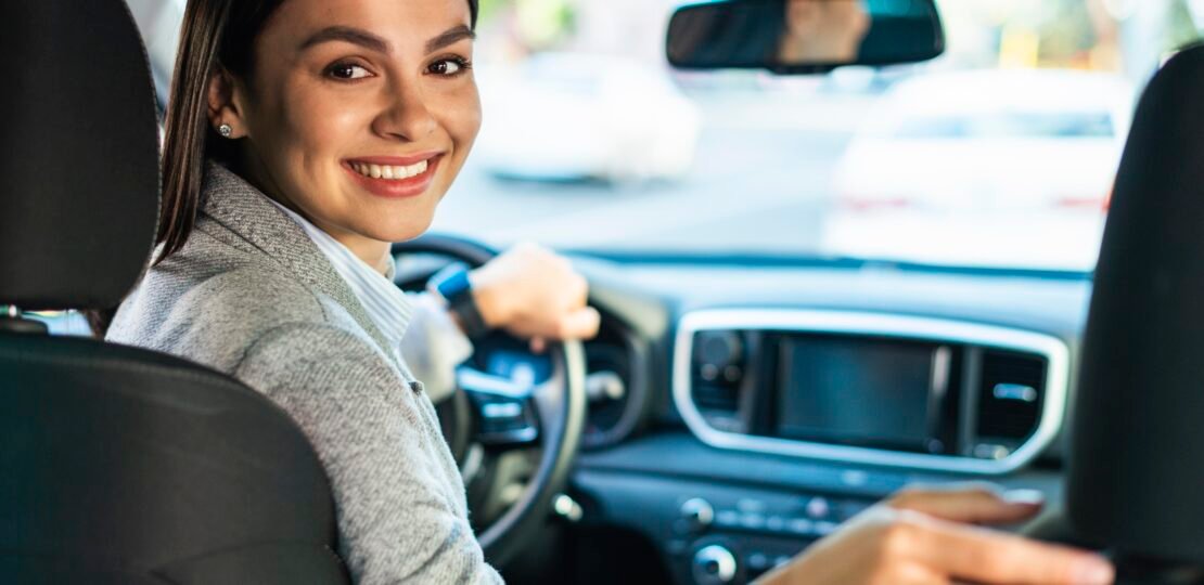 smiley-businesswoman-turning-around-car