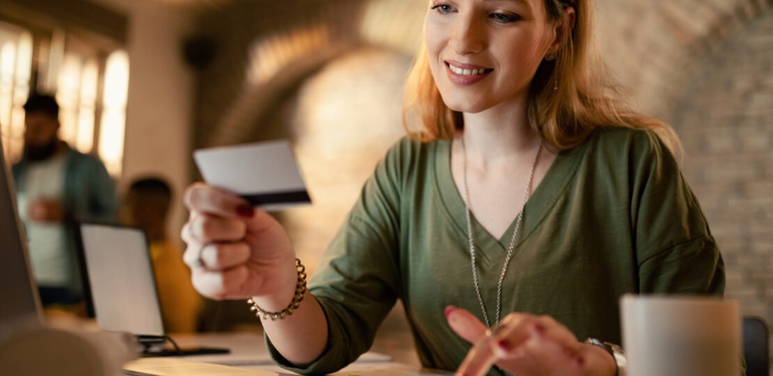 Smiling businesswoman making online payments with credit card an