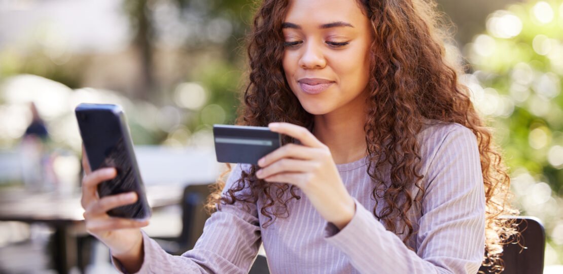 woman-smartphone-credit-card-restaurant-outdoor-with-checking-finance-female-person-paying-mobile-online-payment-cafe-nature-app-with-technology